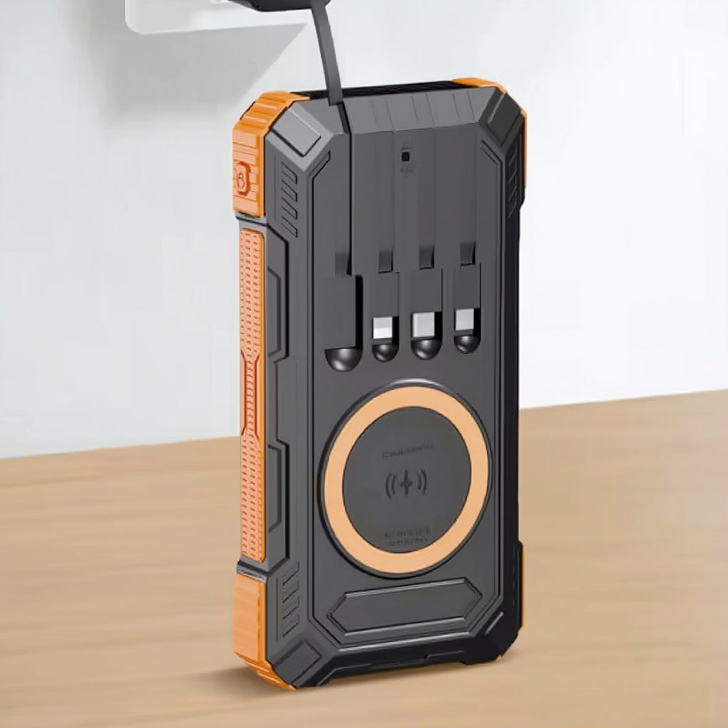 Black and orange power bank with multiple ports on a beige surface