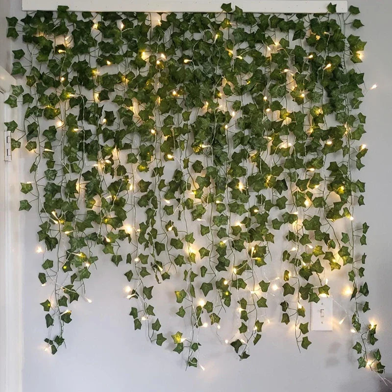 Artificial green ivy wall with string lights on a white background