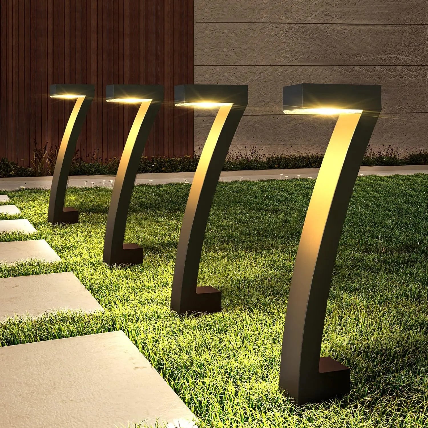 Set of modern outdoor garden lights on grass with a building in the background